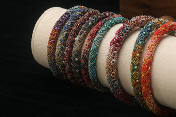 Pulseiras coloridas de miçangas dispostas em um expositor.